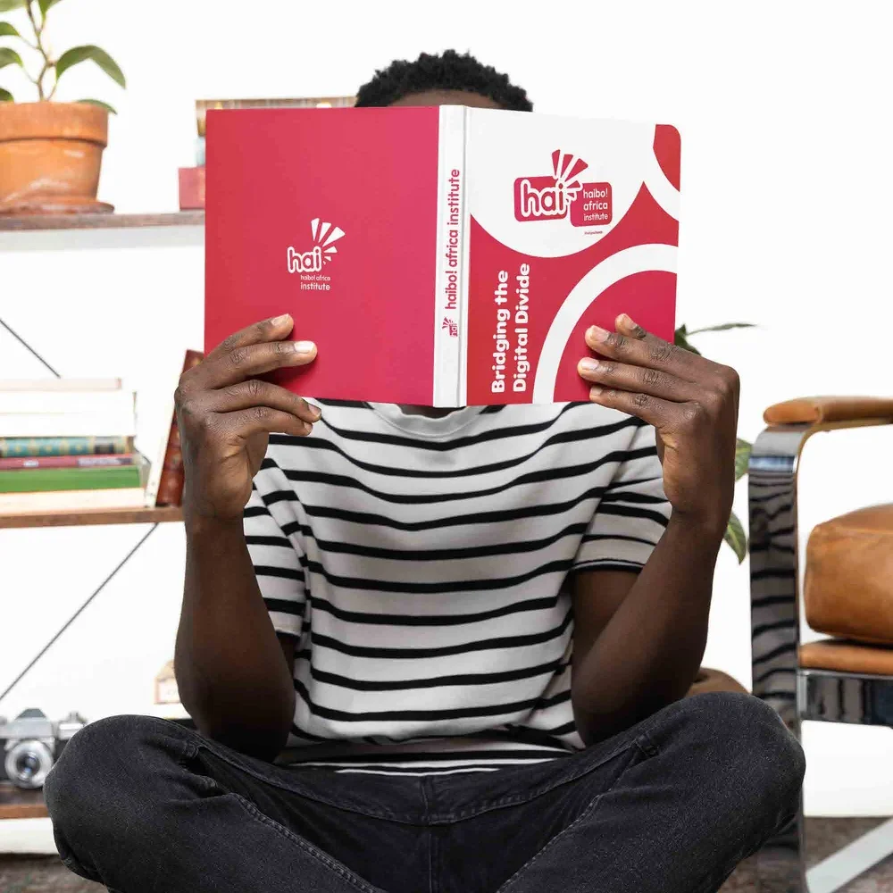 A young South African woman reading and smiling
